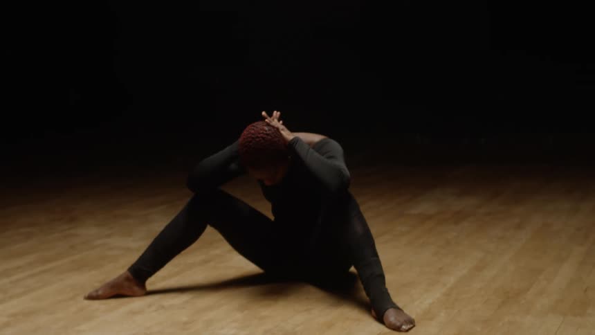 A woman is sitting under the spotlight resting