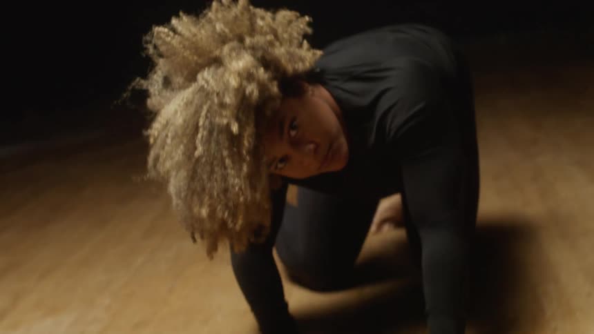 A woman slowly gets up during her performance
