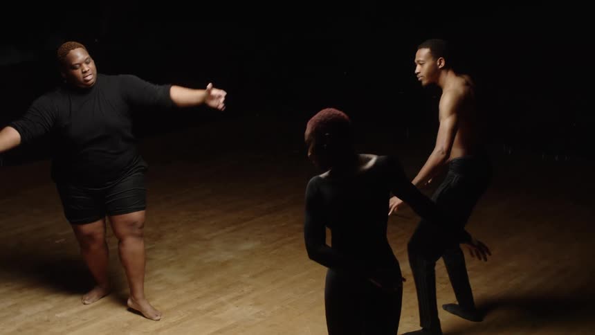 Female and male dancers perform dance arts in spotlight