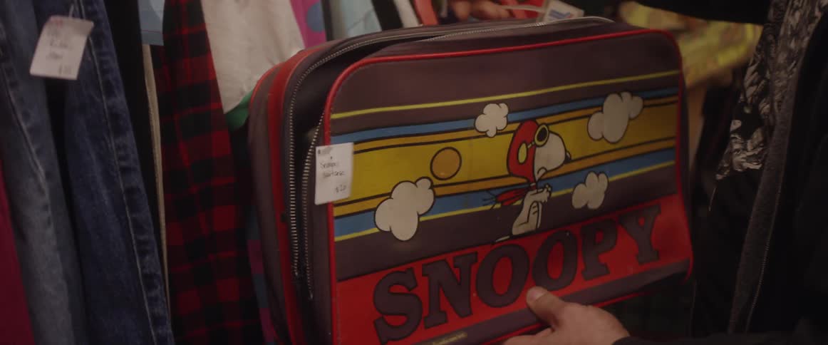 A man looks at a snoopy suitcase