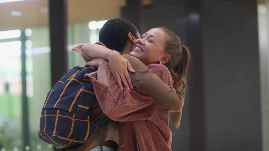 Two friends greet each other and hug