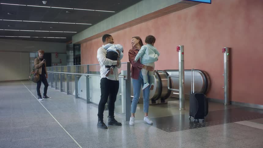 Family reunited near an escalator inside a passenger terminal