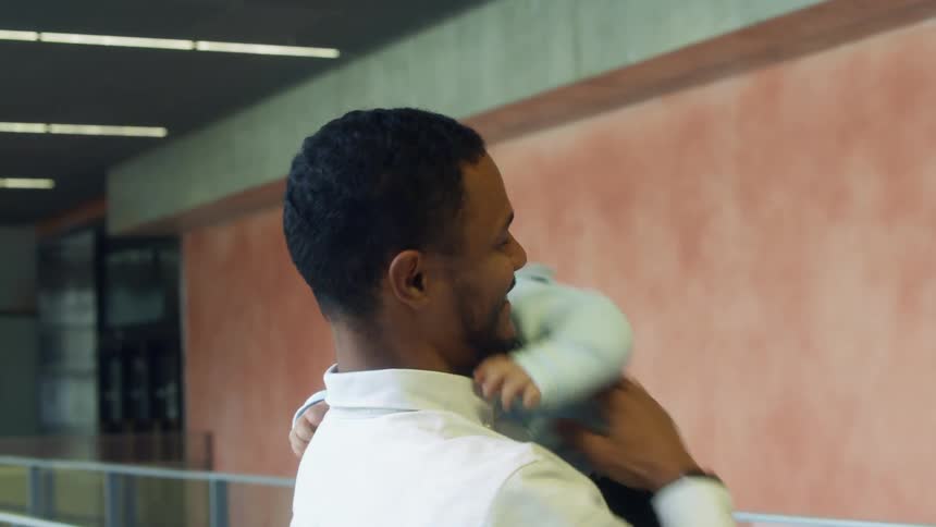 A man spins his baby in the air as they laugh