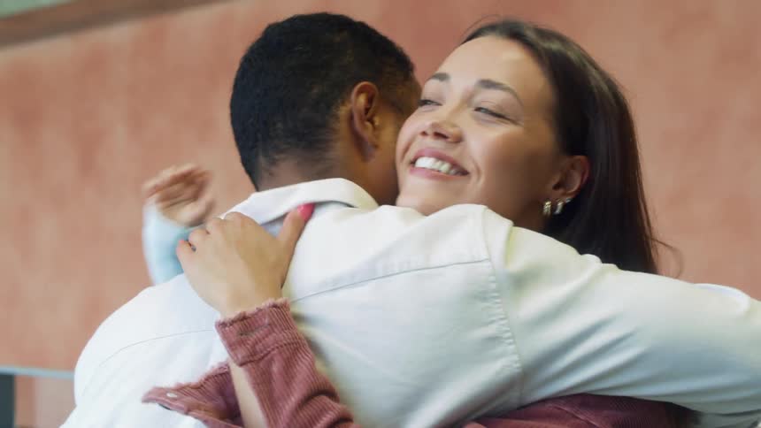 A woman hugs her husband and greets her child