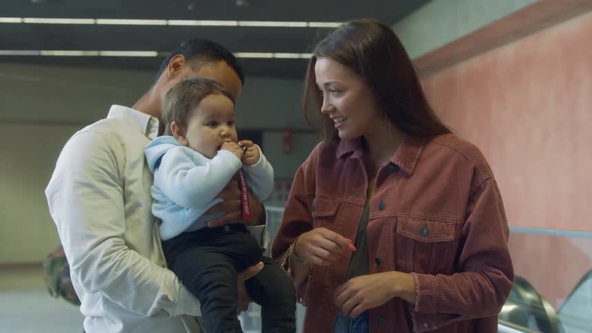 A baby plays with keys as the parents look on