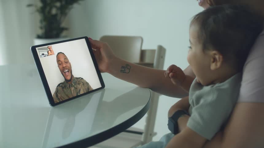Father talking to his family on a video call through a laptop