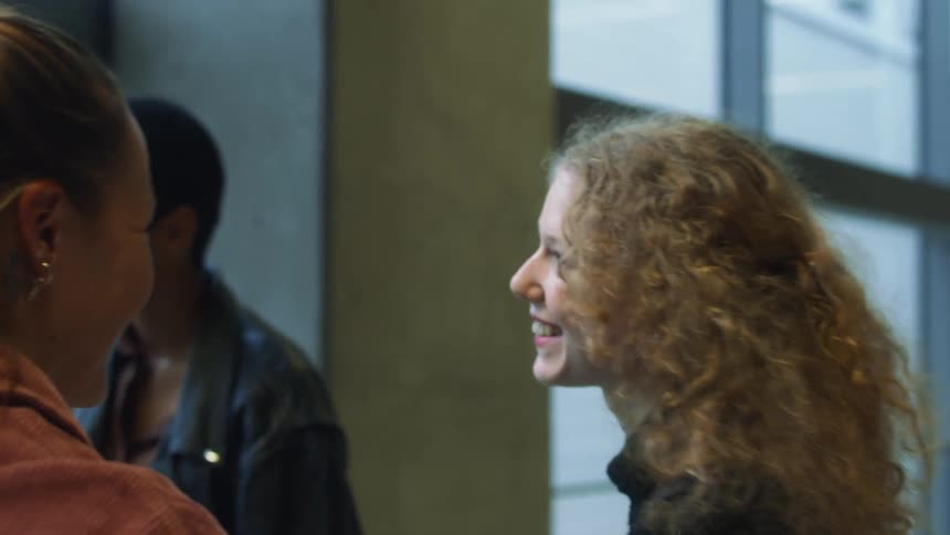 Group of friends greeting each other with hugs at a passenger terminal