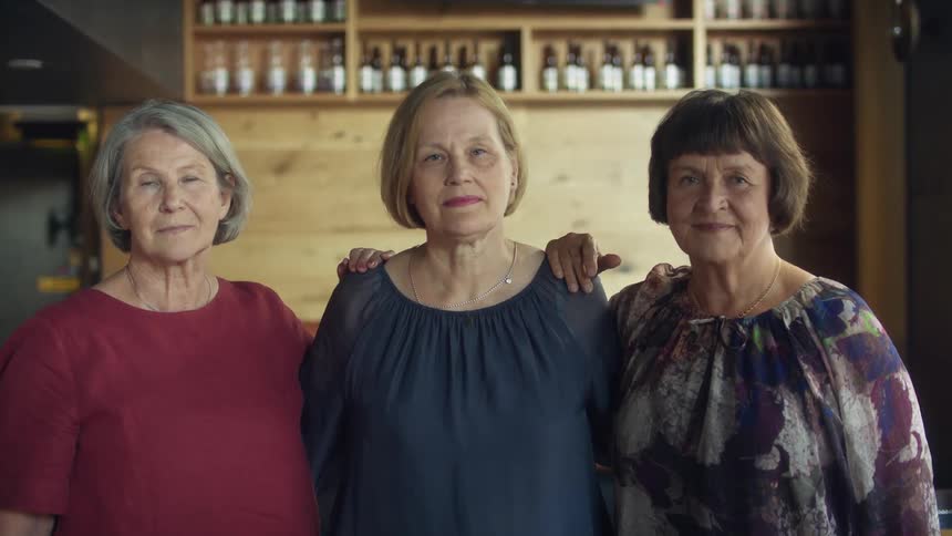 Group of elderly woman looking at the camera standing on a bar