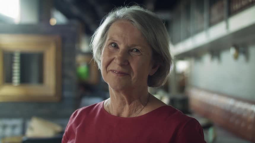 A portrait of a mature woman standing in a restaurant during the day