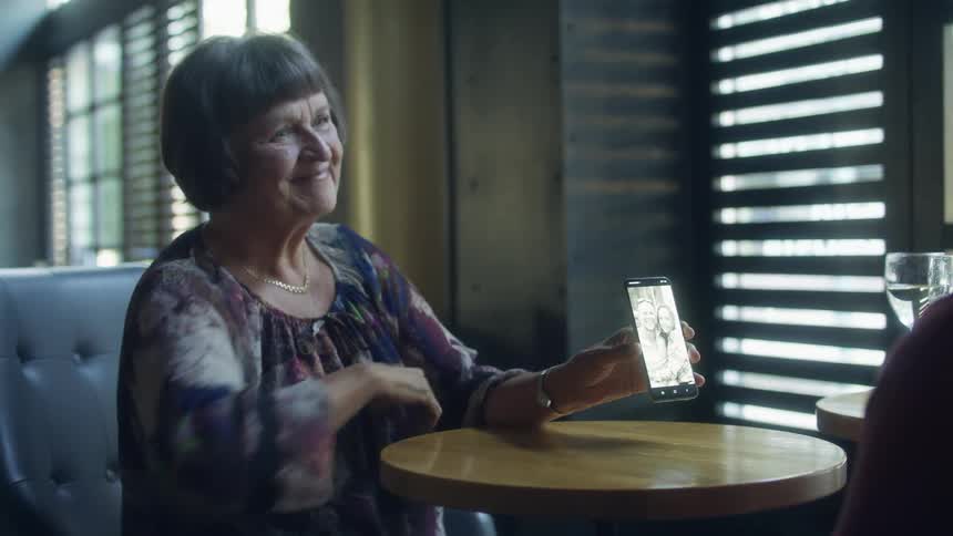 A woman showing another woman a photo on her smartphone