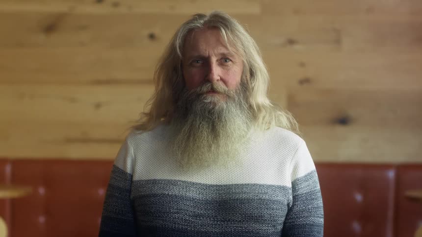 A portrait of a man standing in a room