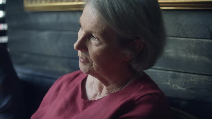 Elderly woman talking while sitting at a table in a restaurant