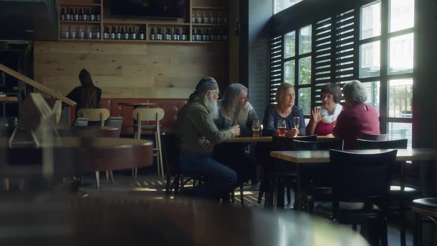 Group of elderly friends talking sitting at a table in a restaurant