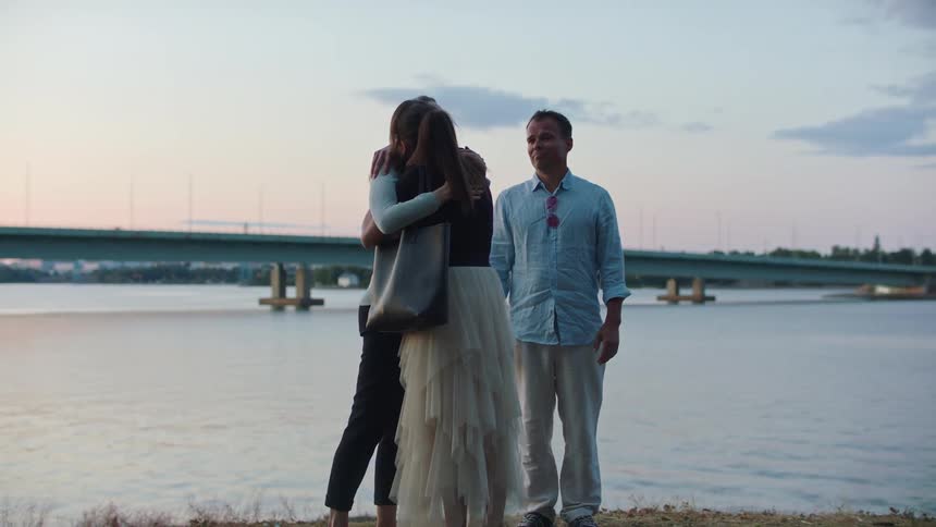 A group of friends talking and hugging outdoors