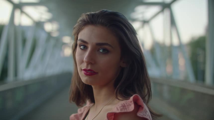 A portrait of a woman standing on a bridge