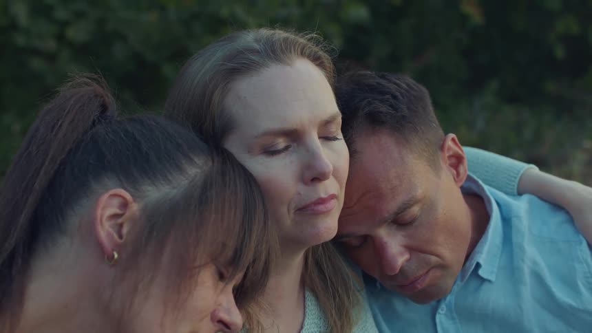 A group of people sitting together with their eyes closed