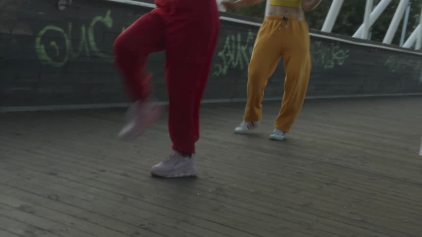 Women are dancing on the walkway together
