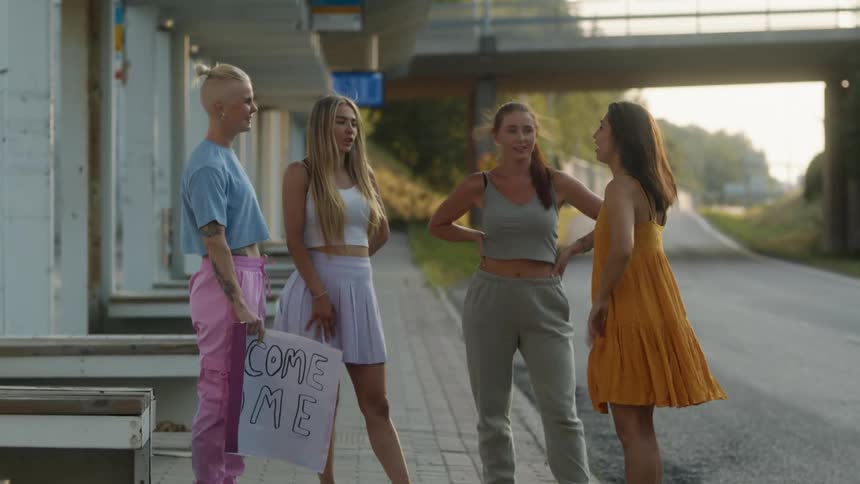 Group of friends talking on the sidewalk of a street at sunset