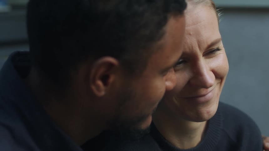 A man comforts a worried woman while sitting outdoors in the daytime
