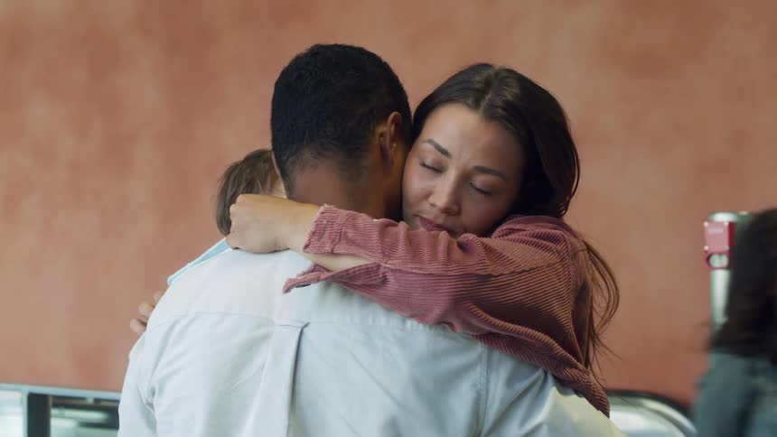 Woman reunites and hugs her her family on a passenger terminal