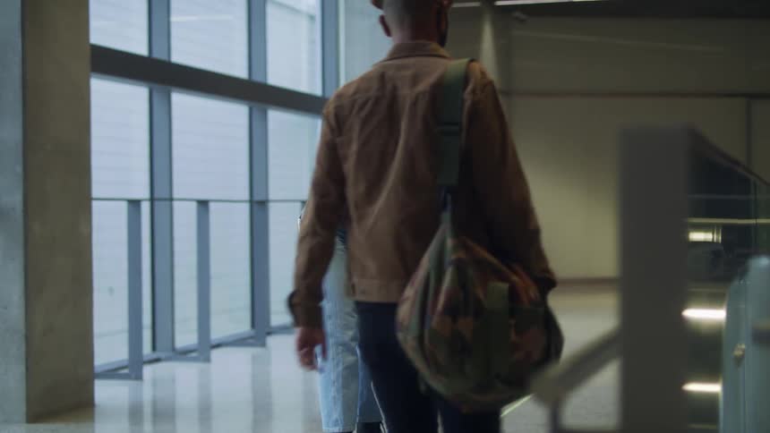 A woman receives her friend at the airport they hug and then move away