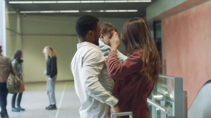 Friends and family greet each other with hugs at terminal