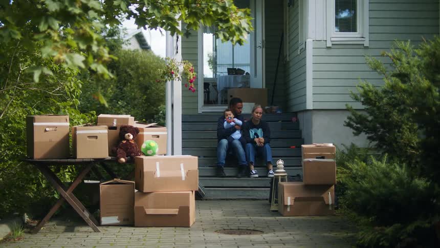 A family console each other as their belongings sit outside