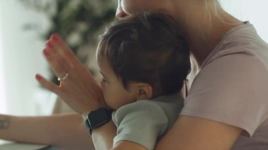 Blonde mother holds toddler baby making a video call