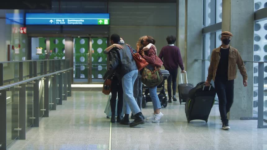 Group of friends greet each other with hugs on the passenger terminal