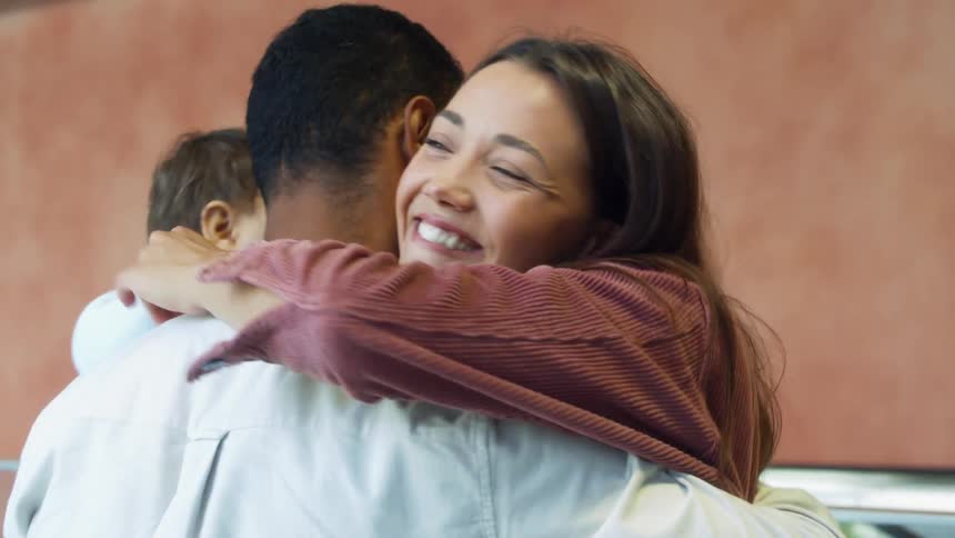 Family reunited in a passenger terminal hugging each other