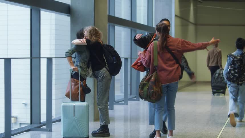 Young friends greeting each other in a transport terminal