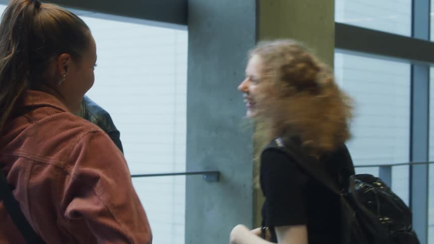 Group of friends greeting each other with hugs and laughs at the passenger terminal