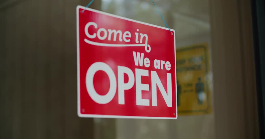 An open sign hangs in the window of a business