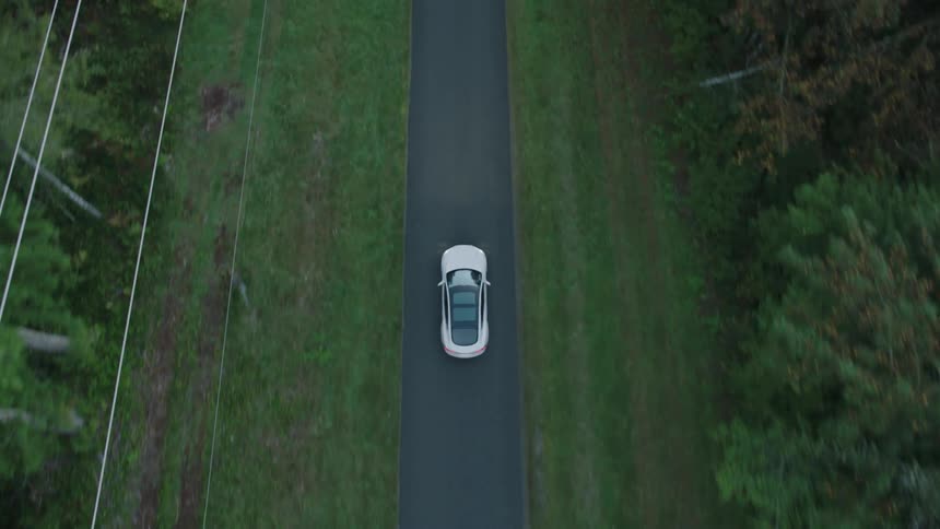 Aerial view of a car driving down a single lane road