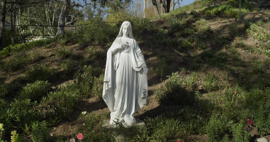 A white statue is on the hill outside