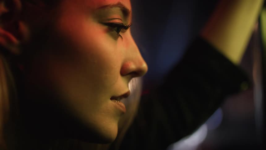 A woman is moving her head up and down as she is paying attention to something
