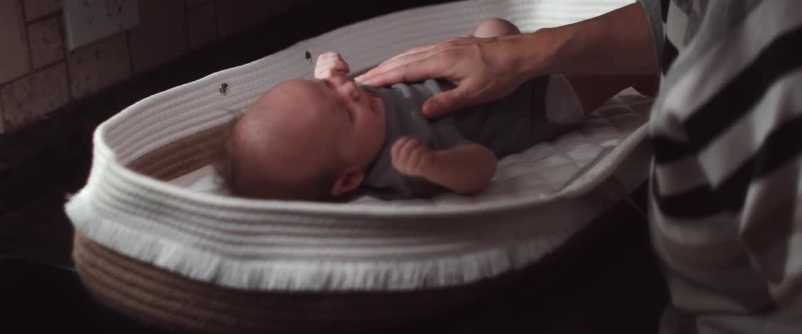 A hand lovingly rubs a babys tummy soothing him