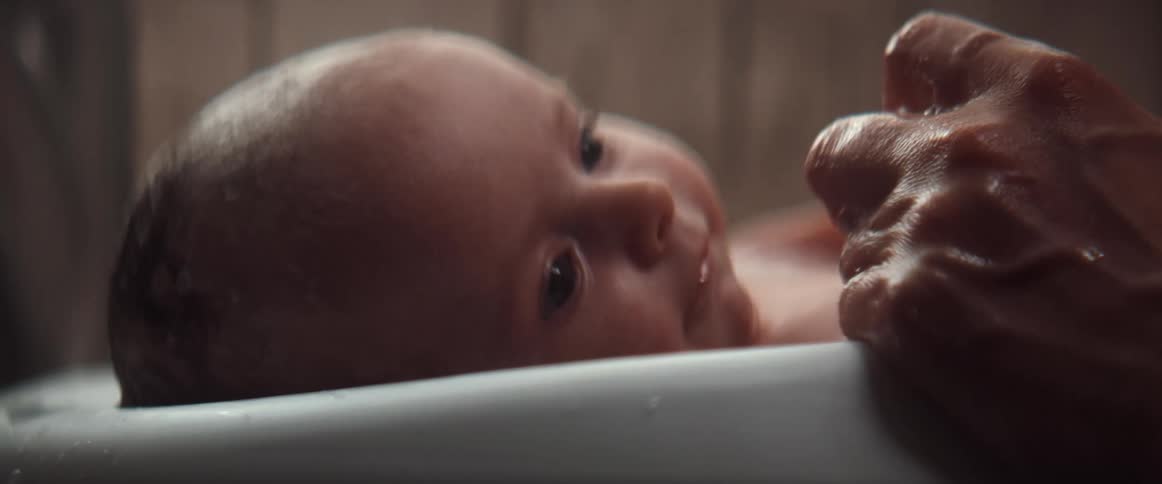 Mother giving a baby a bath on a portable bathtub