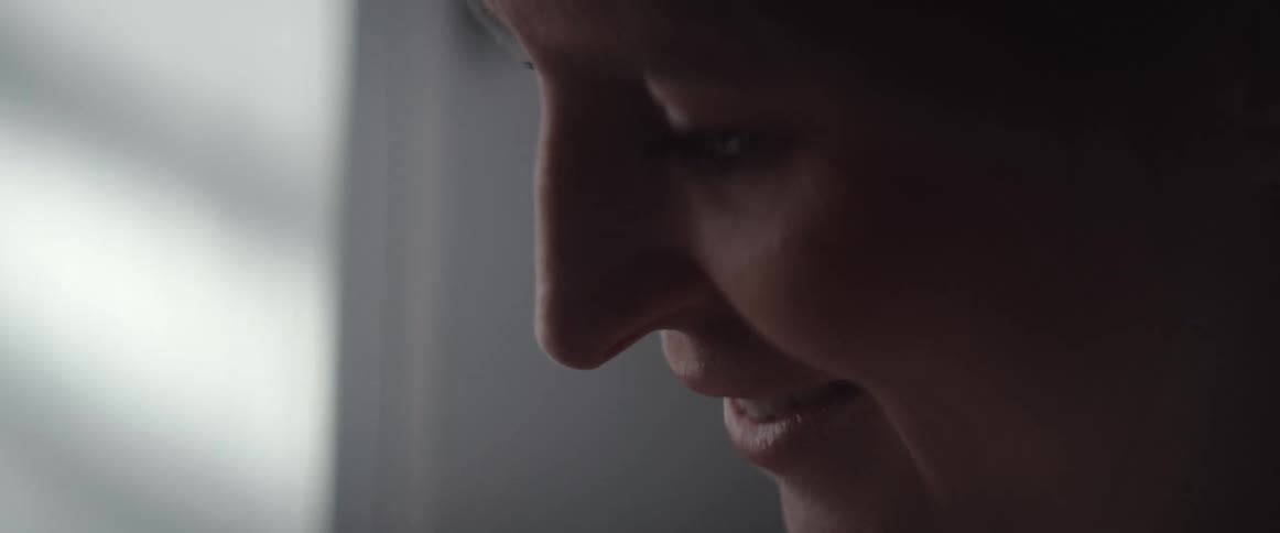 A woman in a room with a wall in the background