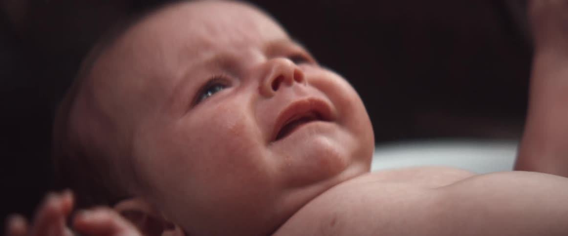 A crying naked newborn