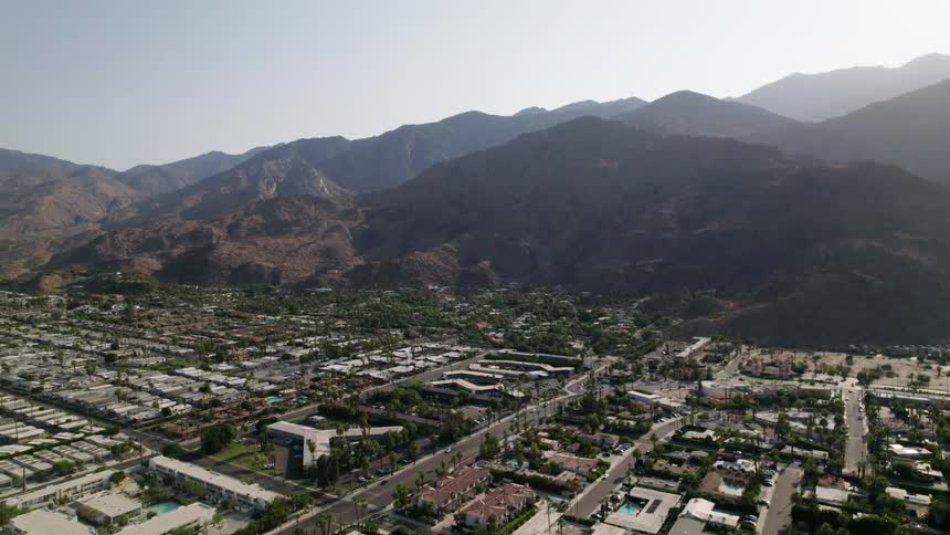 A sprawling city area lays just beneath a large mountain range