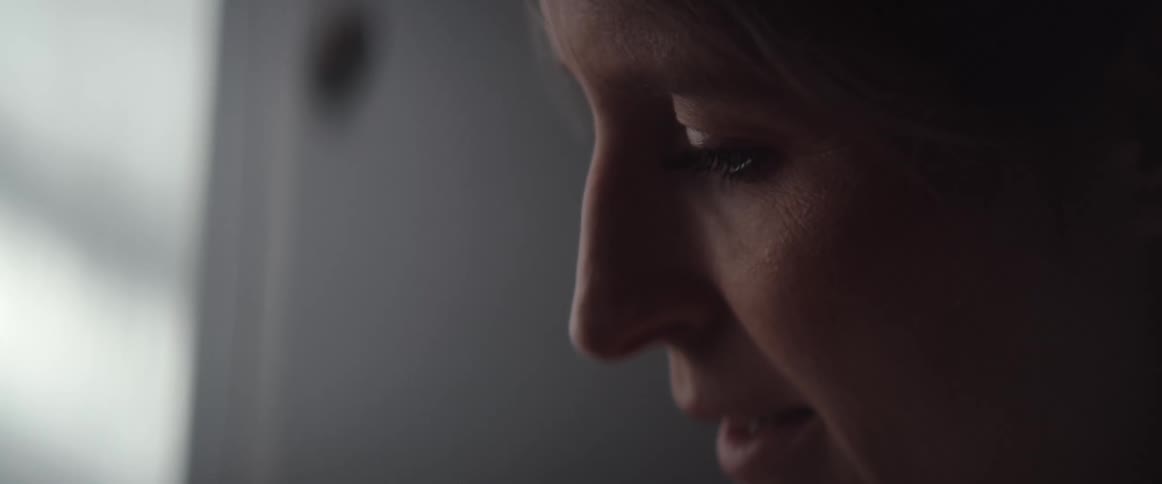 A woman in a room with a wall in the background