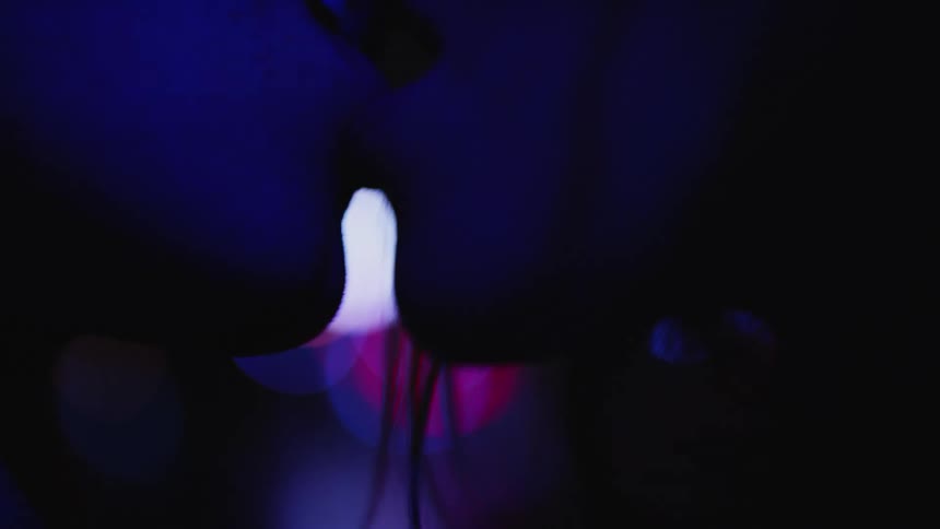Man and woman kiss under a blue colored light