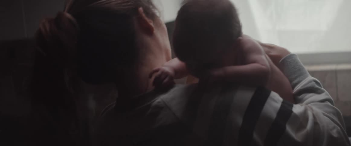 A mother cradles her child at home