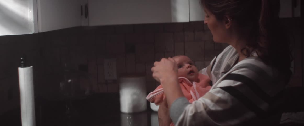A woman holding a baby and rocking the baby back and forth