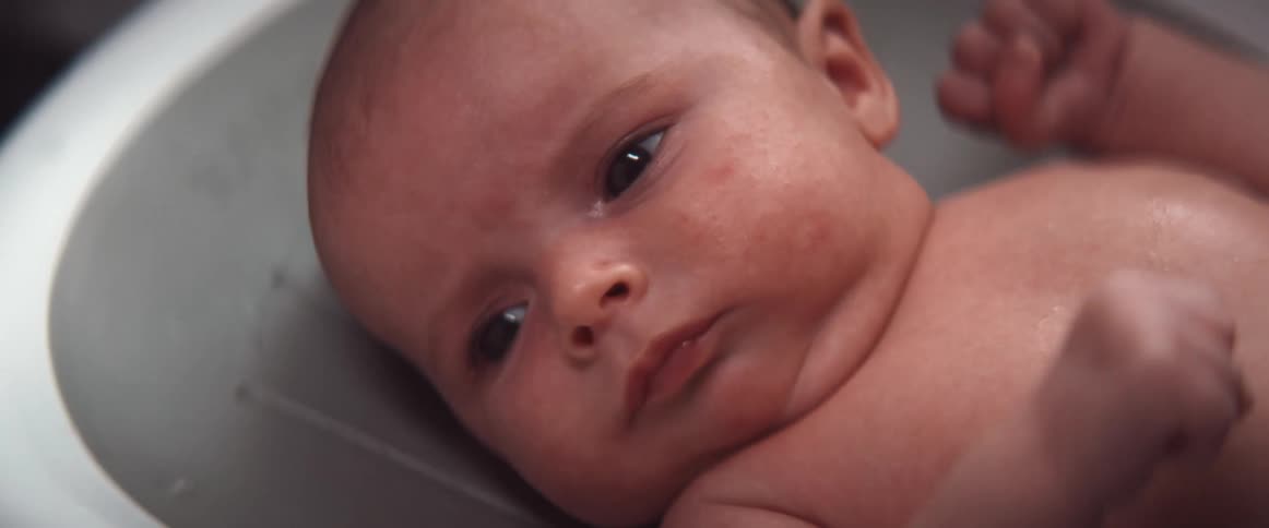 A baby lies in an infant tub