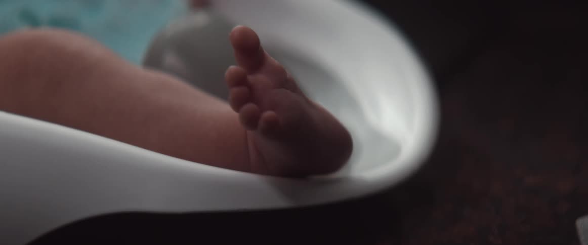 A baby is moving its food around