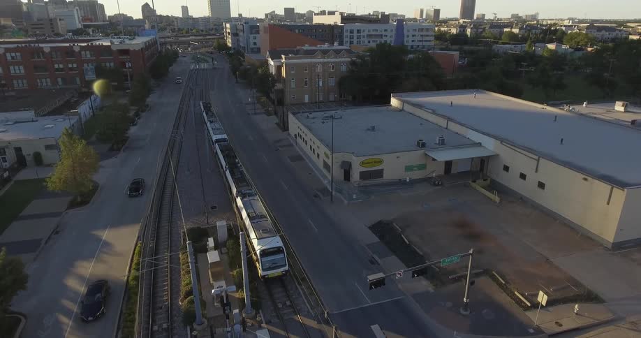 A train on tracks goes beside cars on road