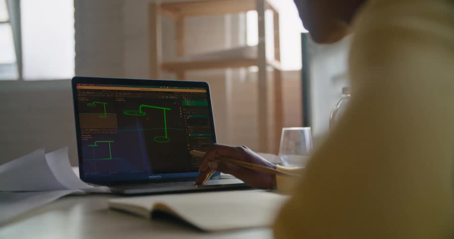 A woman is sitting at a desk working on a laptop