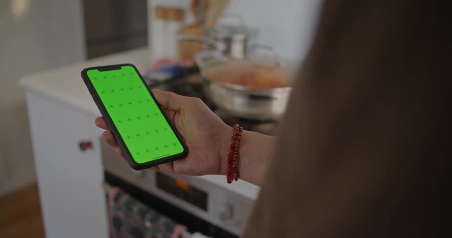 A person is holding a cell phone in their hand with the screen illuminated